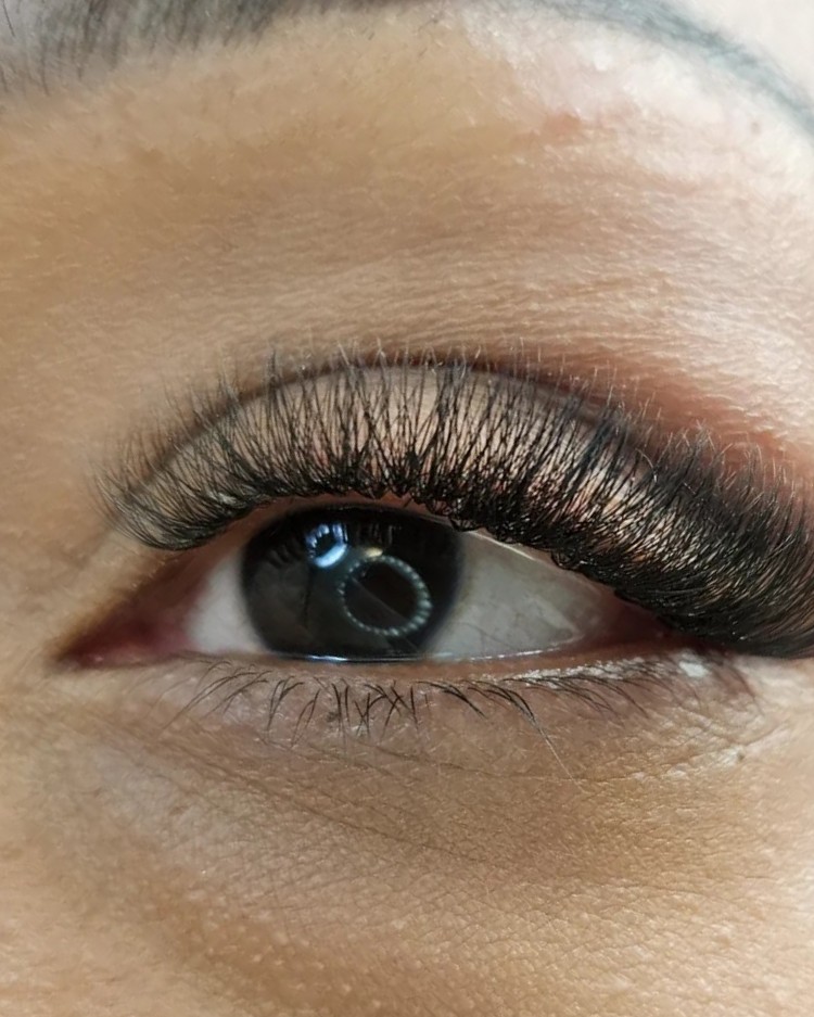 Close-up van een oog met een volle, zachte set wimperextensions