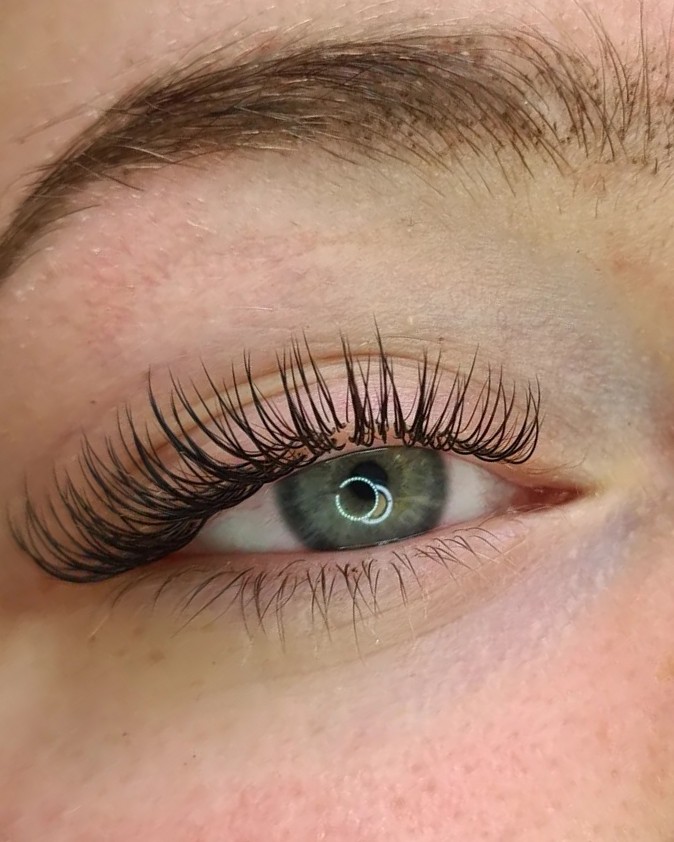 Close-up van een oog met een luchtige, natuurlijke set wimperextensions